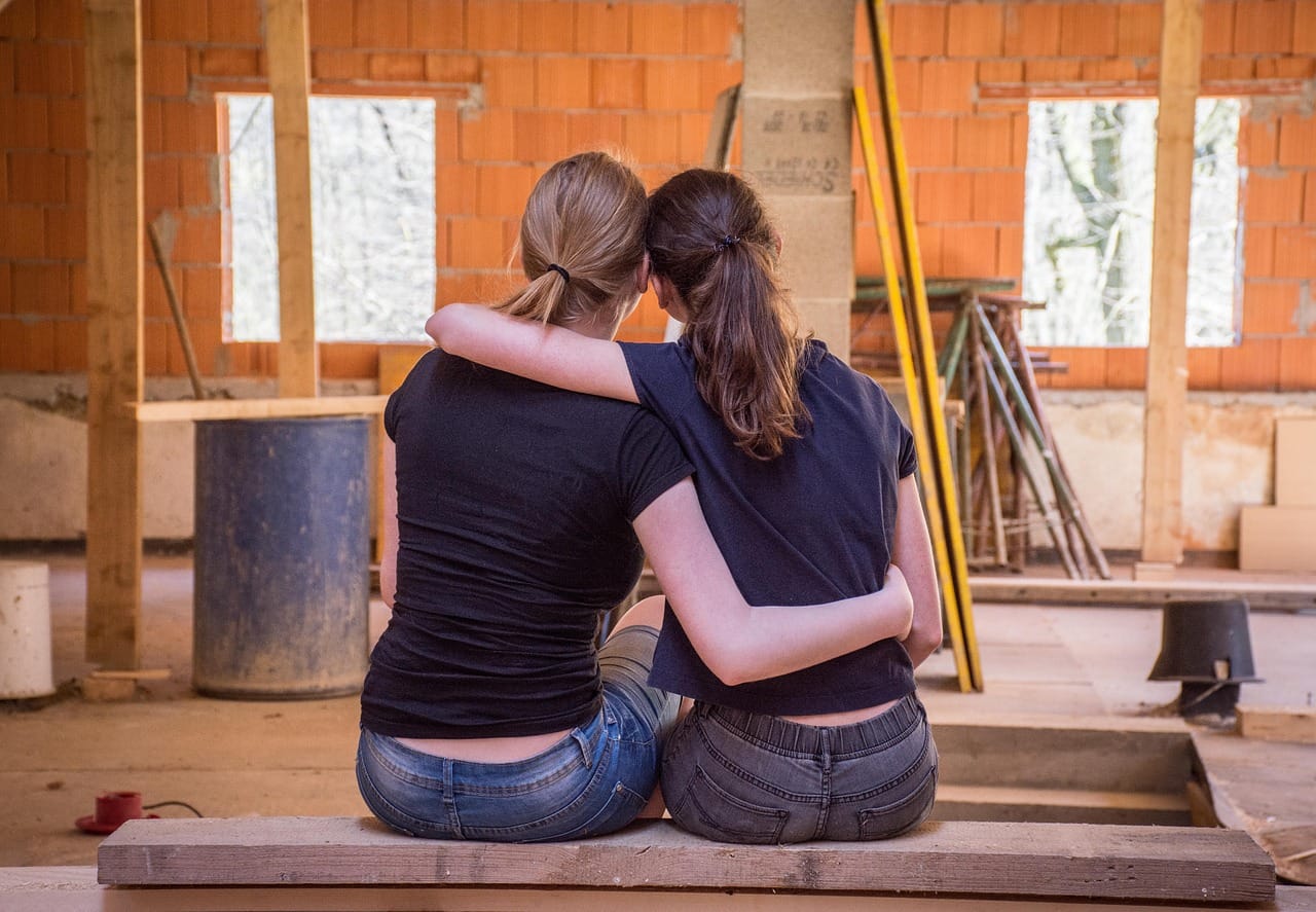 Couple surveying the task ahead for their refurbishment project with stacks of wood and tools in the background. The Acorn.finance renovation mortgages team make this dream into reality. Part of a Buy, Refurbish, Refinance, Rent strategy
