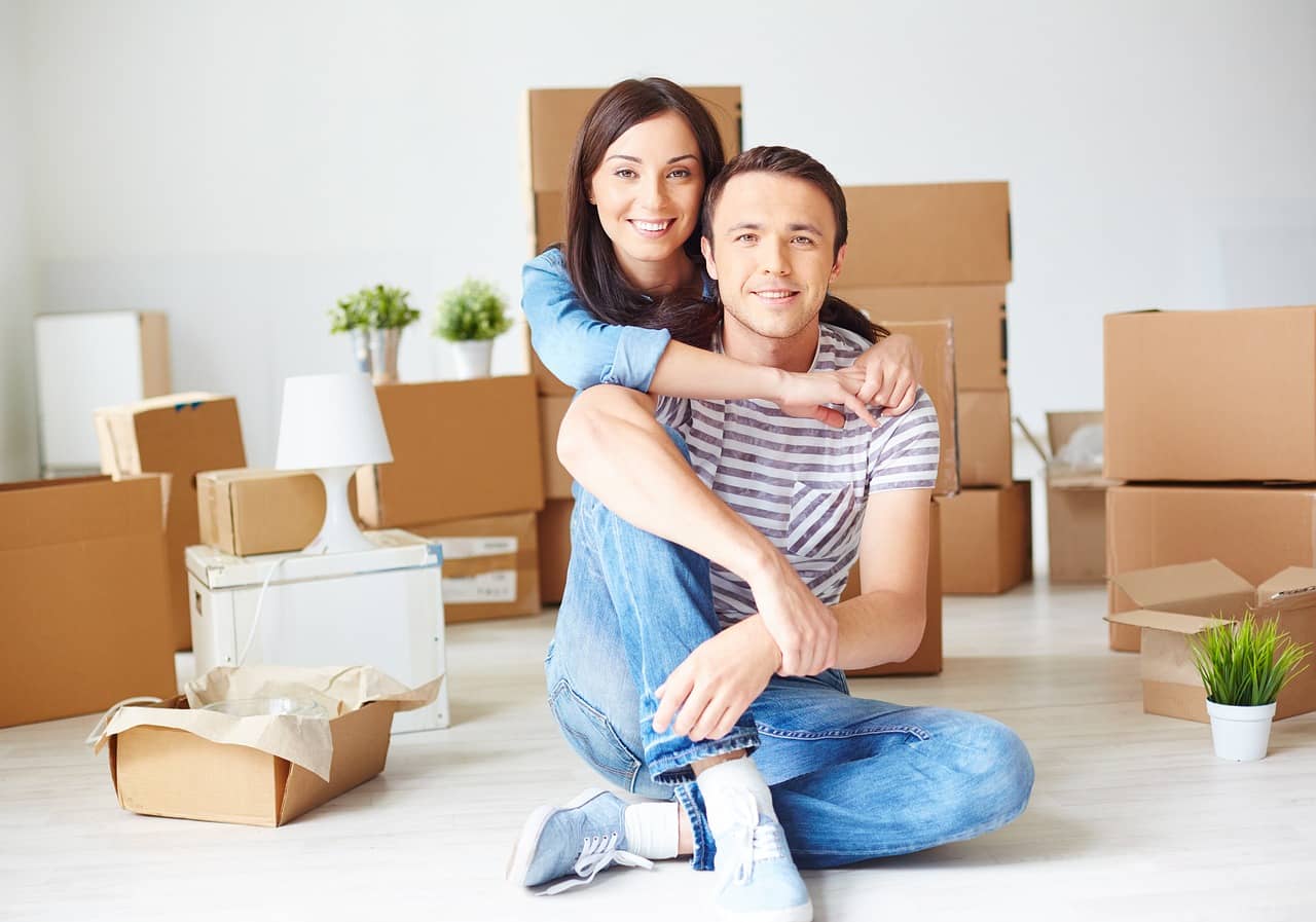 Couple having just moved into their new rental home in the private rental sector (enabled by Buy to let mortgages and bridging loans) 